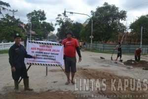 Puluhan warga Desa Baning Kota dibawah  terik matahari bergotong royong memperbaiki ruas jalan provinsi 